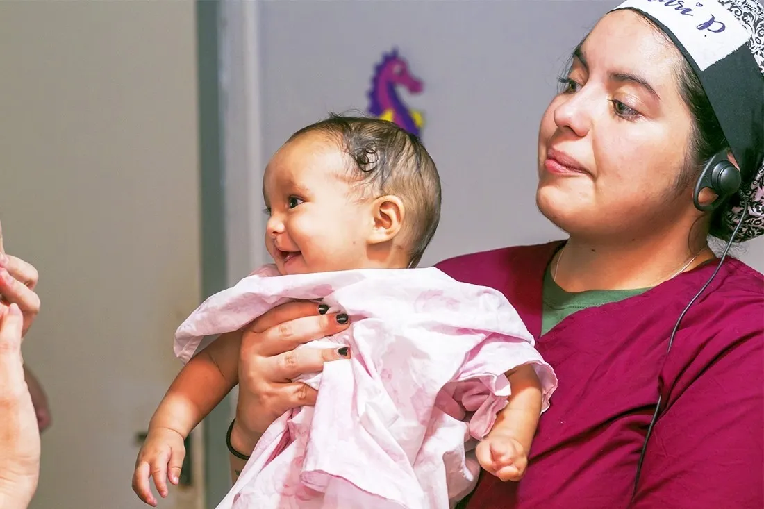 Elizbeth, held by an Operation Smile Brazil volunteer.