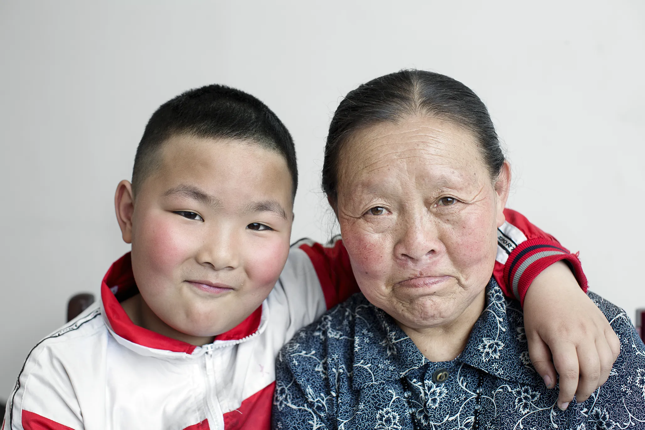 Qi Xiu smiles wide with her grandson.