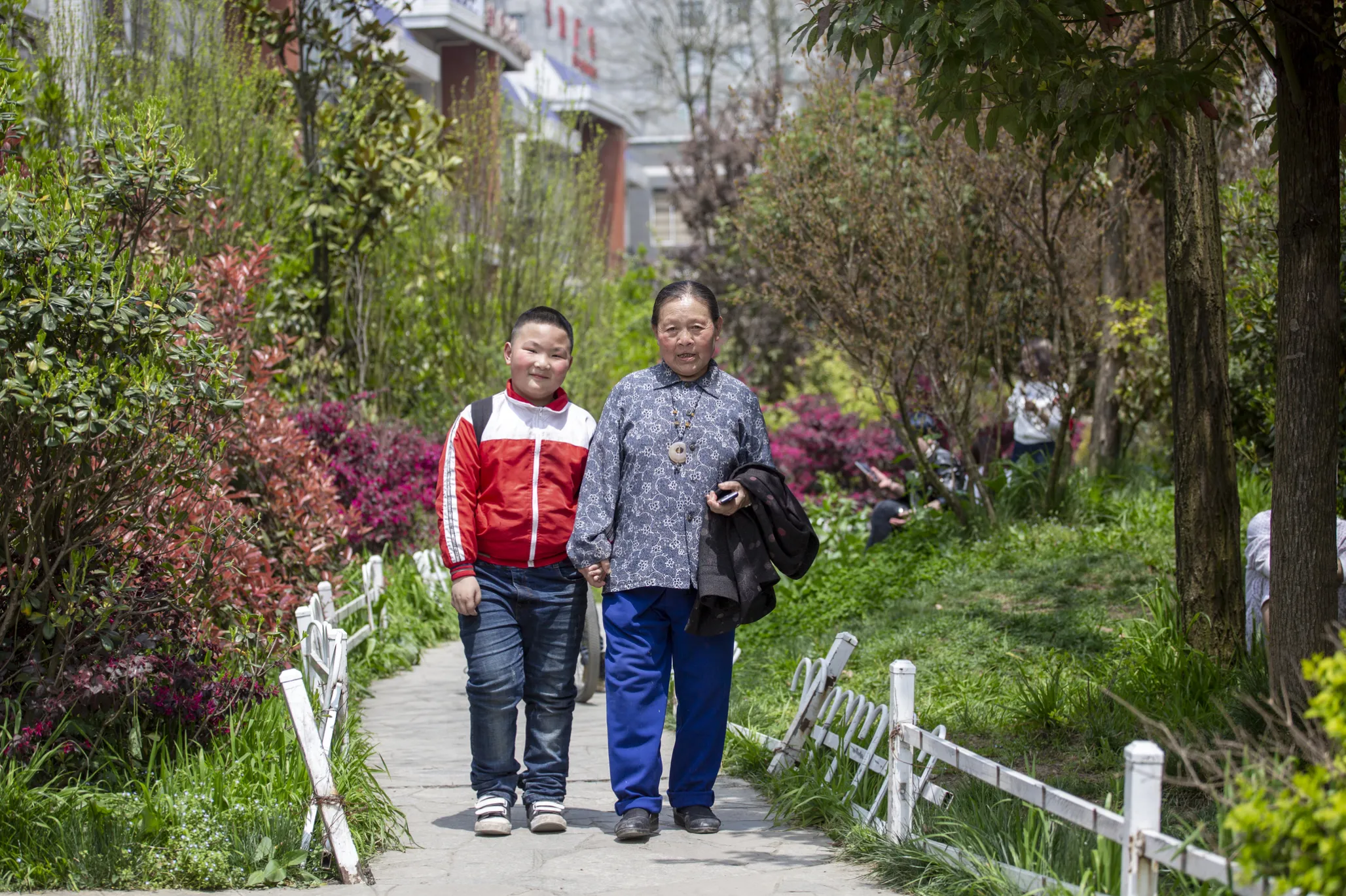 Qi Xiu walks with her grandson.