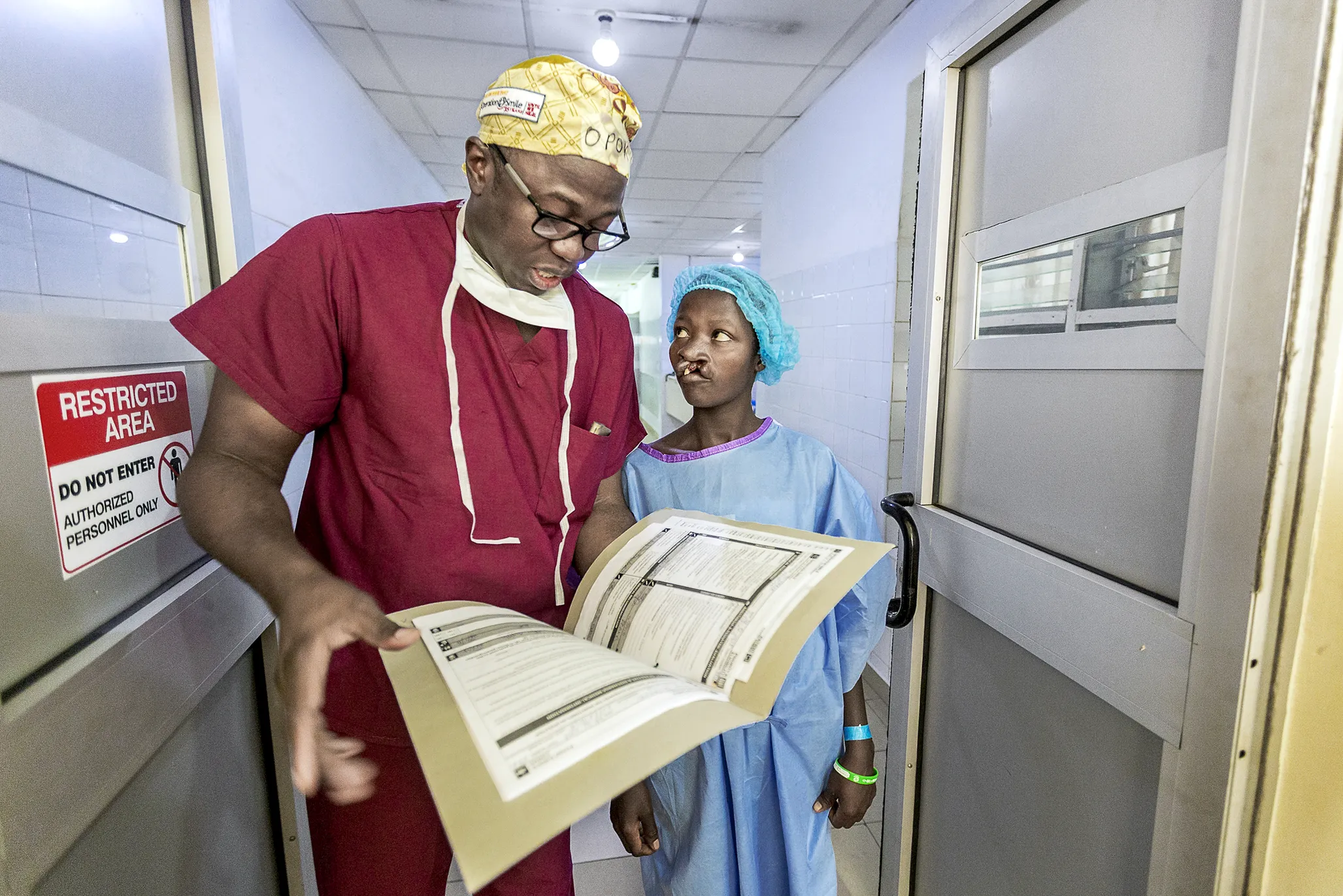 Operation Smile Ghana medical director and cleft surgeon Dr. Opoku Ampomah talks to 17-year-old patient Faustina before her cleft lip surgery during the January 2018 surgical program at Eastern Regional Hospital in Koforidua, Ghana.