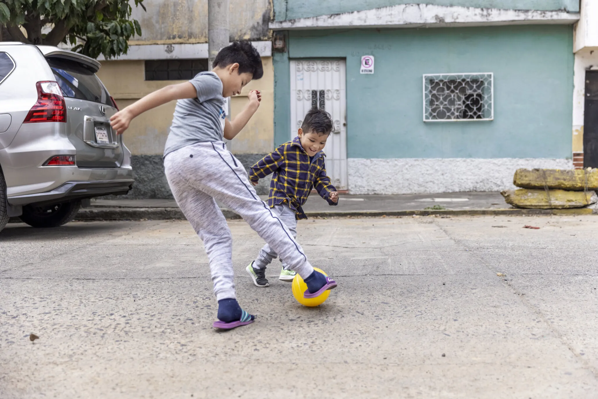 Two years after surgery, Dilan and his friend play with a soccer ball together outside his family’s home in Guatemala City.