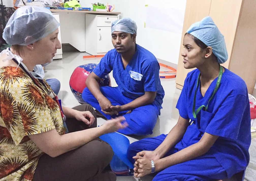 Operation Smile volunteer child life specialist Jennifer Fieten, left, explains her role on the Operation Smile medical team to an IQ City Narayana Multispecialty Hospital nurse, center, and nursing student during the Future of Smile surgical program's educational workshop.