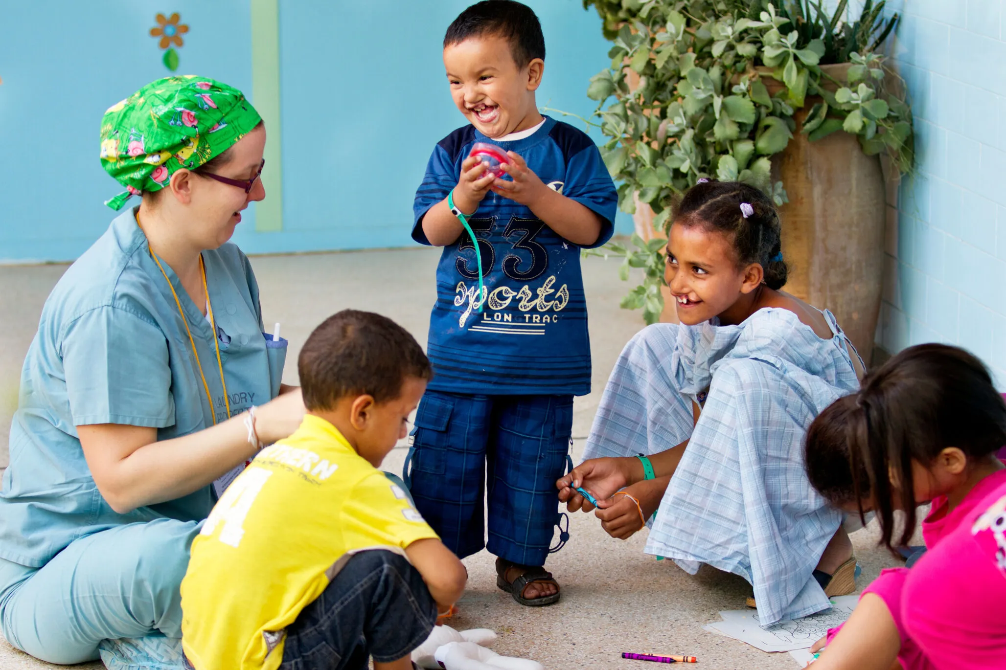 During a 2011 surgical program in Morocco, volunteer child life specialist Jen Burton Liang of Canada uses therapeutic play with a group of patients as they wait to be taken into the operating room for surgery.