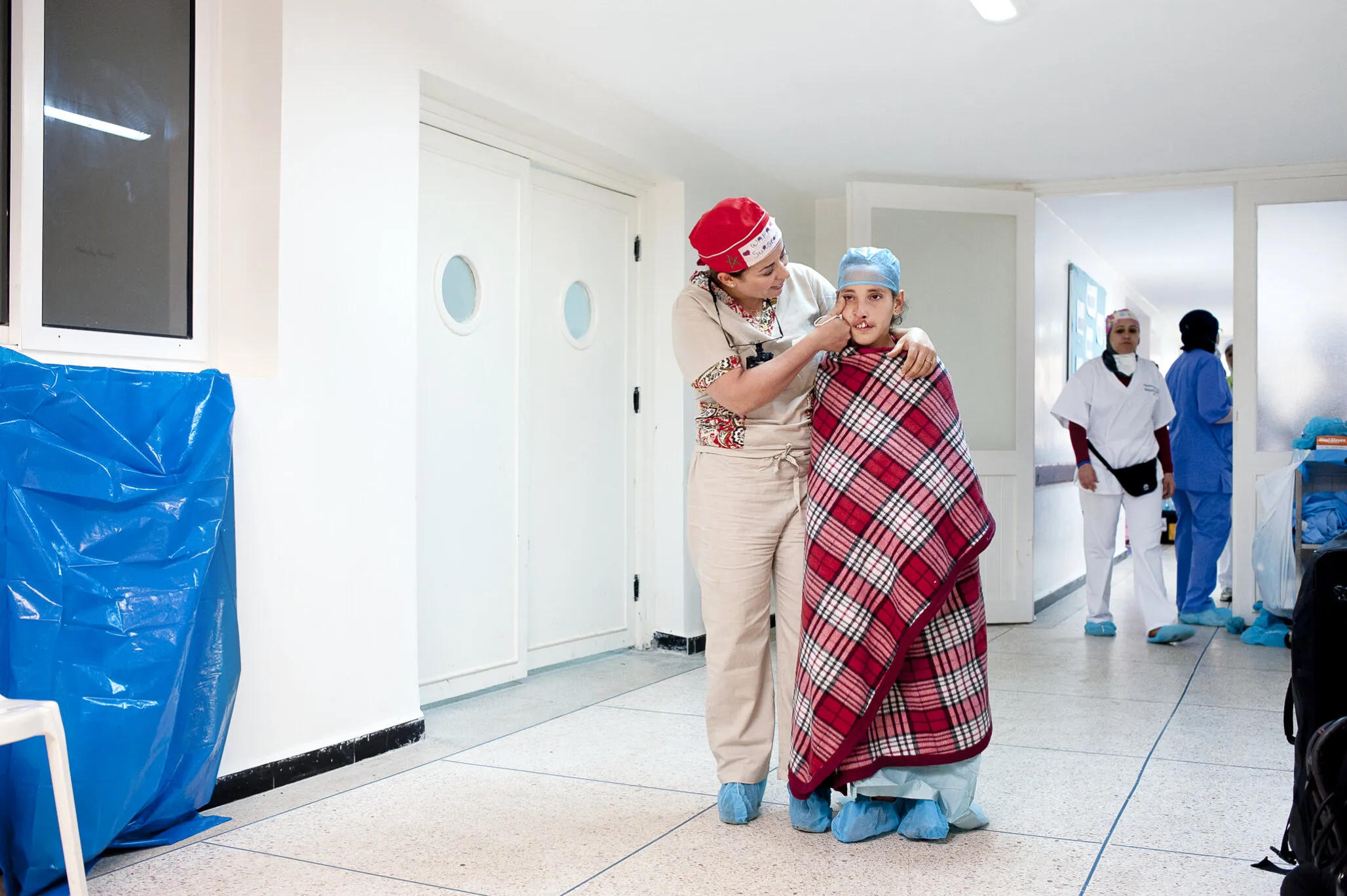 Siham walks with volunteer surgeon Dr. Wafaa Mradmi toward the operating room.