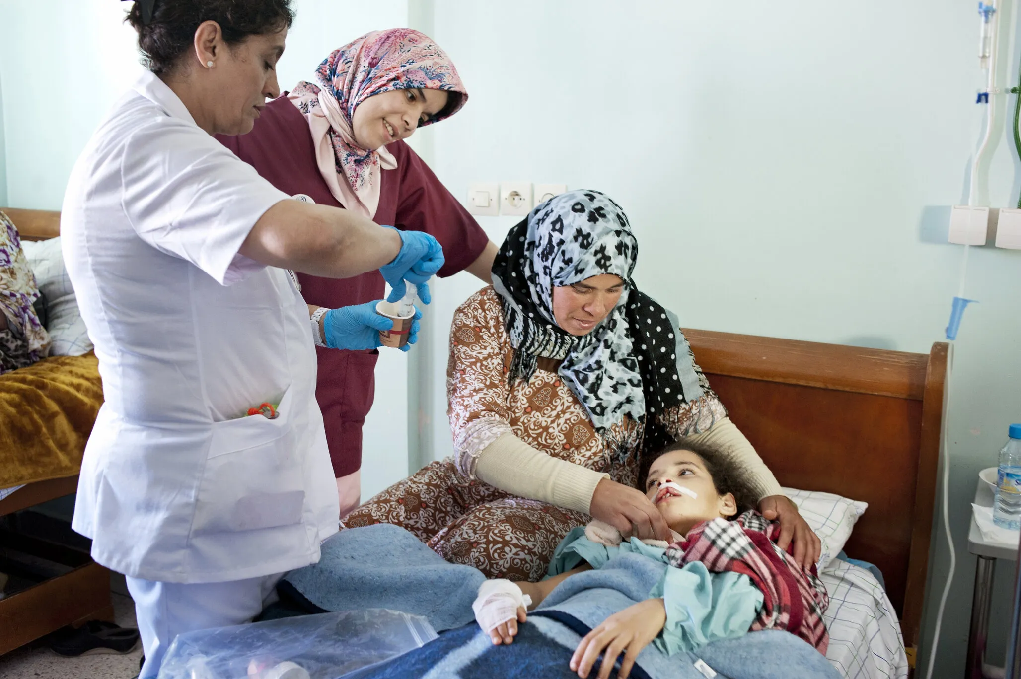 Siham's mom, Samira, holds her daughter in the recovery room after surgery.