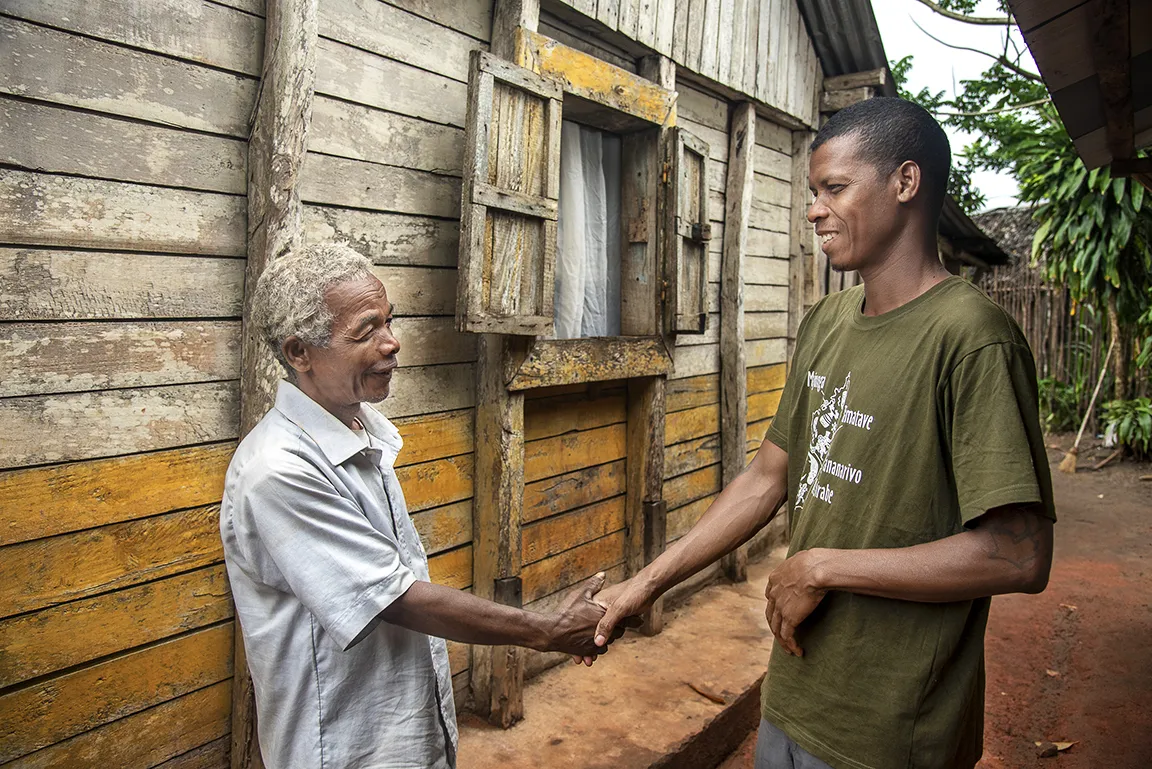 Patient advocate Fidelis shakes the hand of 52-year-old Alfred.