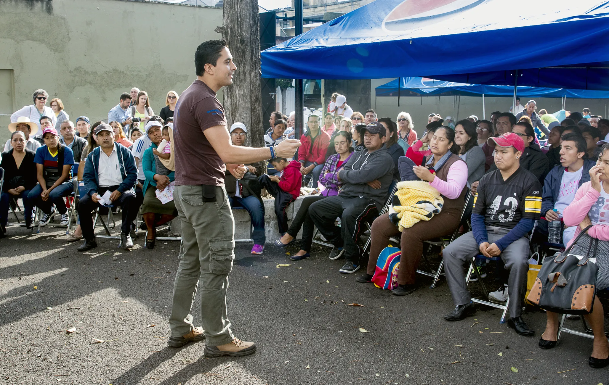 Executive Director Mauricio Rojas, who was previously a program coordinator for Mexico, speaks to parents and patients during patient announcement day at a 2016 surgical program in Puebla, Mexico.