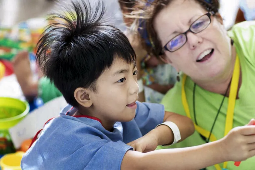 Operation Smile volunteer psychosocial care provider Sandy Forseth and a patient engage in therapeutic play at a surgical program in Vietnam.