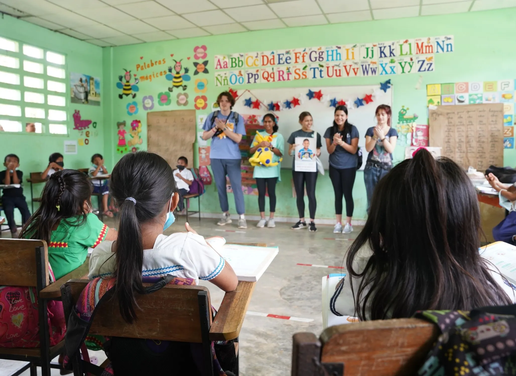 Student Program volunteers speak with children during a surgical program.