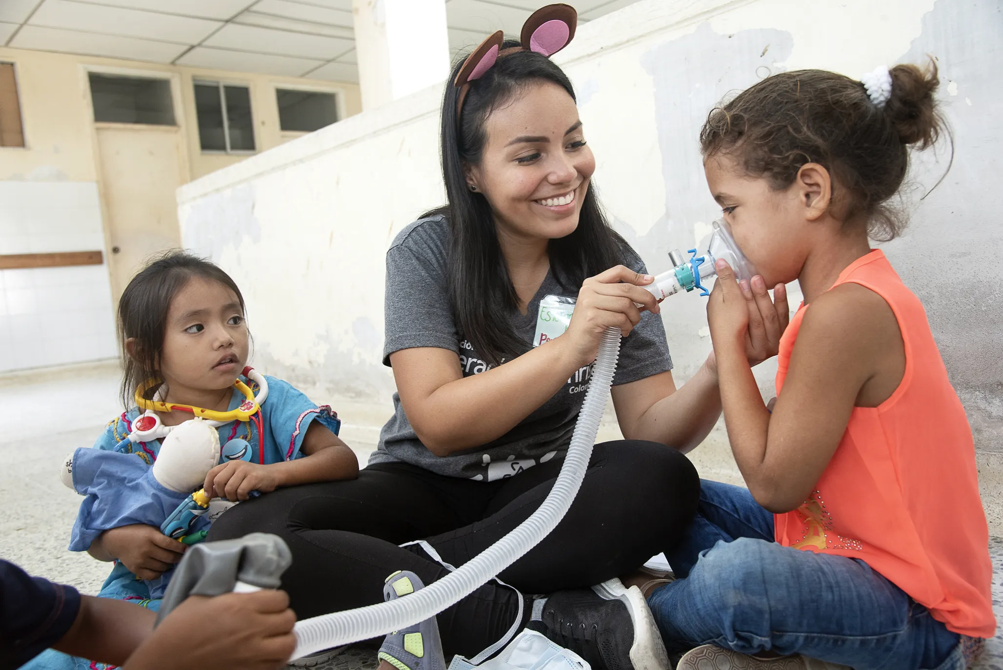 A patient practices with a mask during a child life session at a program in Colombia.