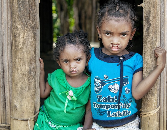 Sisters Nambina and Vaviroa stand beside one another in the doorway of their family home. 