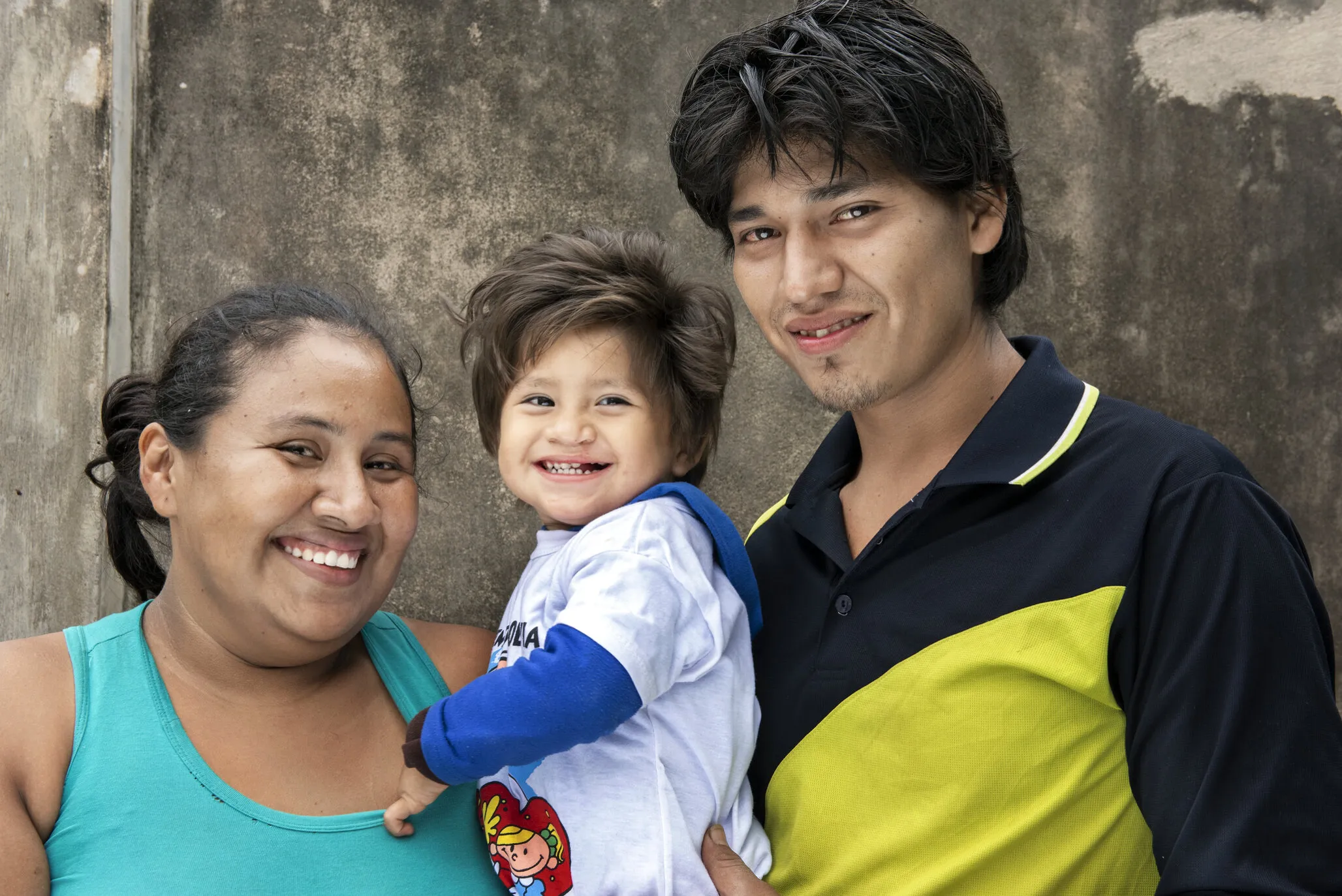 Nora, Damian and his dad, Alexander, share their smiles seven months after Damian received his cleft lip surgery.