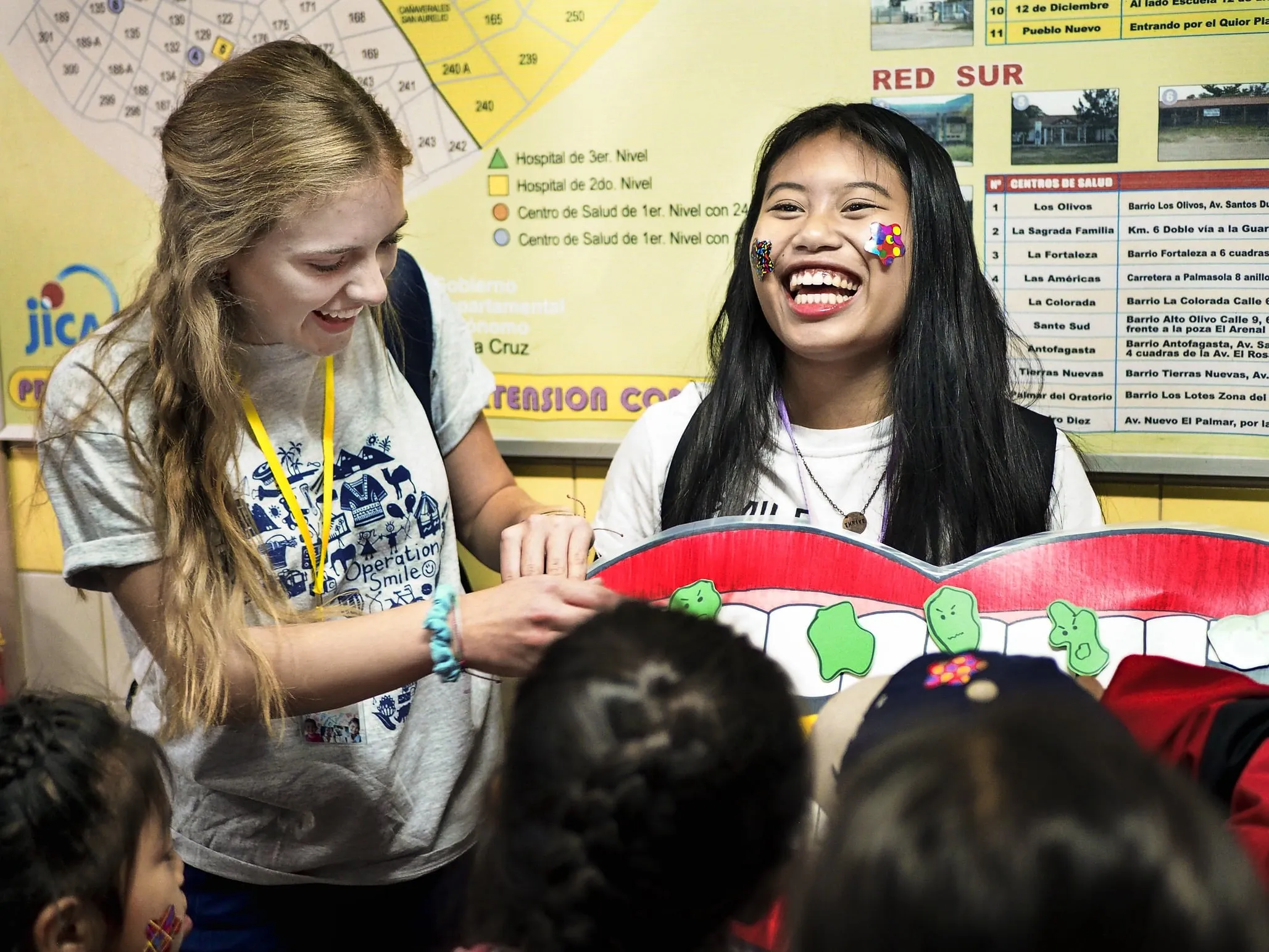 Operation Smile student volunteers laugh while sharing information about oral care.