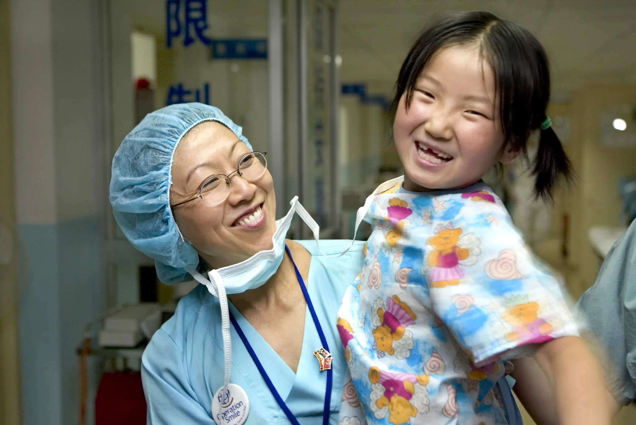 A volunteer and patient smile together during a surgical program in 2005 in China.