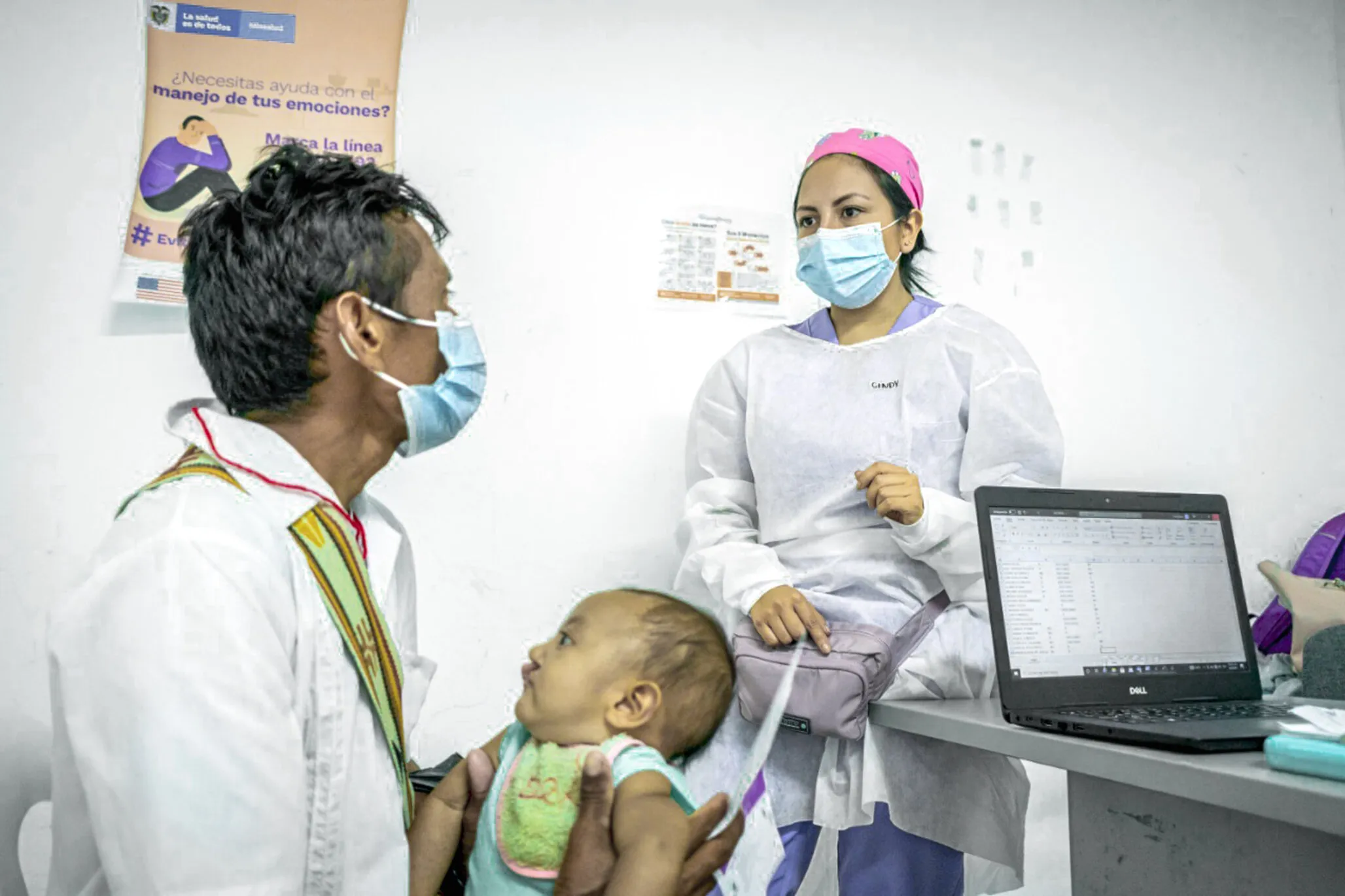 Operation Smile Colombia volunteer nutritionist Cindy Getial consults with a father about the nutritional status of his son, Enoc, during an August 2021 program in which ready-to-use therapeutic food was distributed to families living in La Guajira, Colombia, a remote region where food insecurity threatens the lives of patients living with untreated cleft conditions.