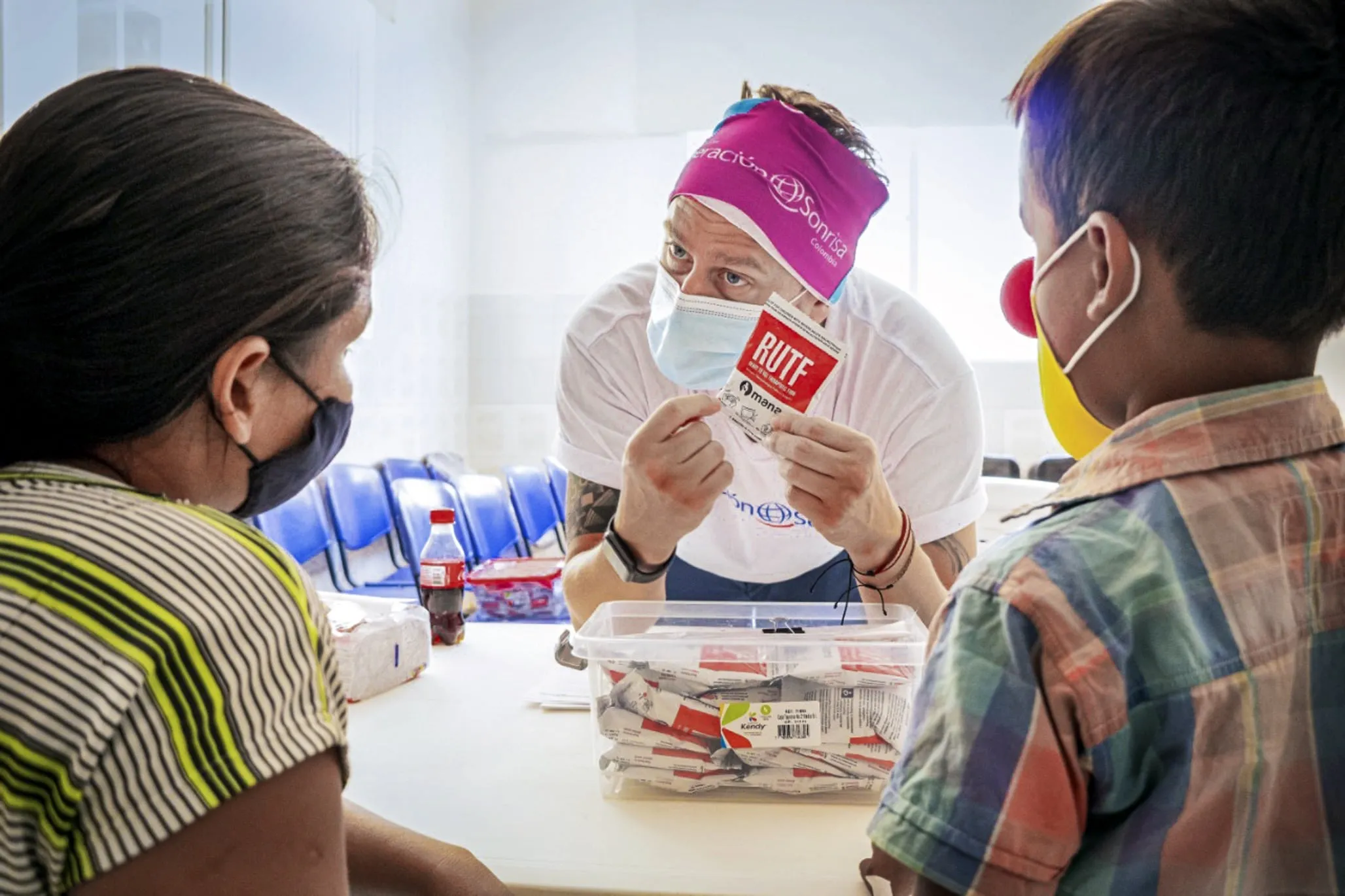 An Operation Smile Colombia volunteer explains the benefits of ready-to-use therapeutic food (RUTF) to a family living in the remote region of La Guajira, Colombia.