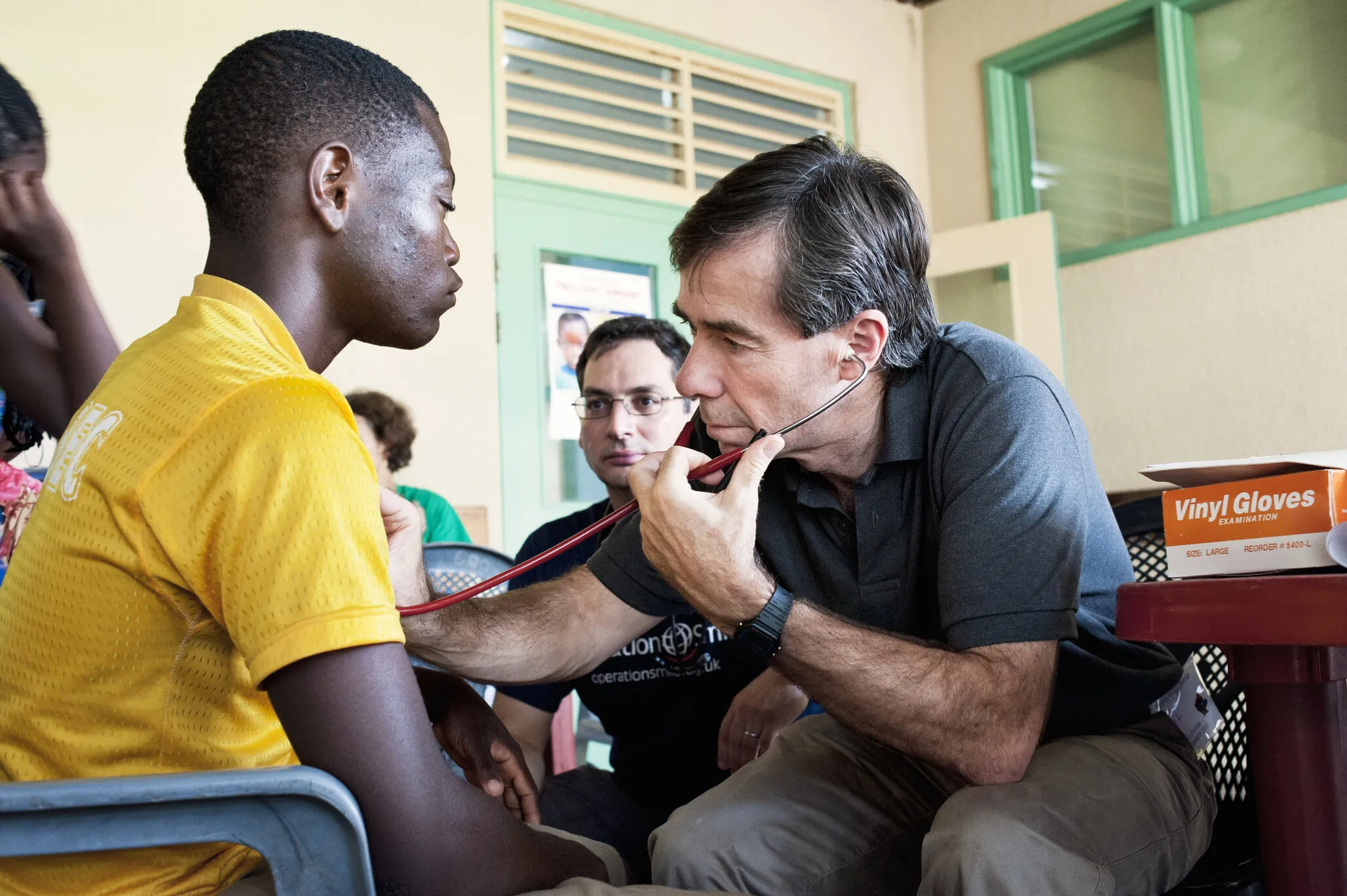 Samuel is evaluated by anesthesiologists Drs. Clive Duke, left, and Phil McDonald of the U.K., right.