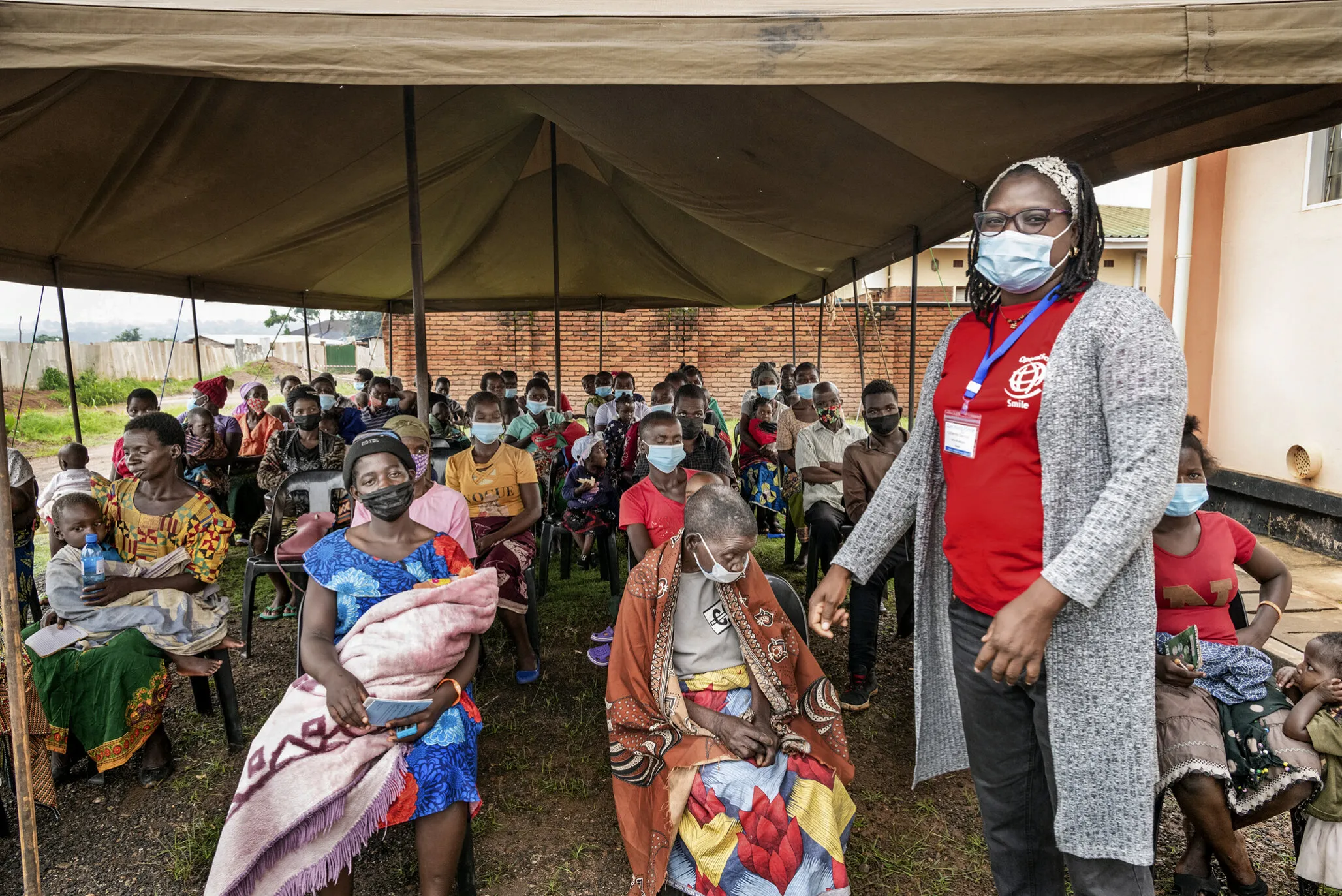 Psychosocial care provider Cathy Cheonga interacts with families of patients at screening during a 2022 Operation Smile Malawi surgical program.