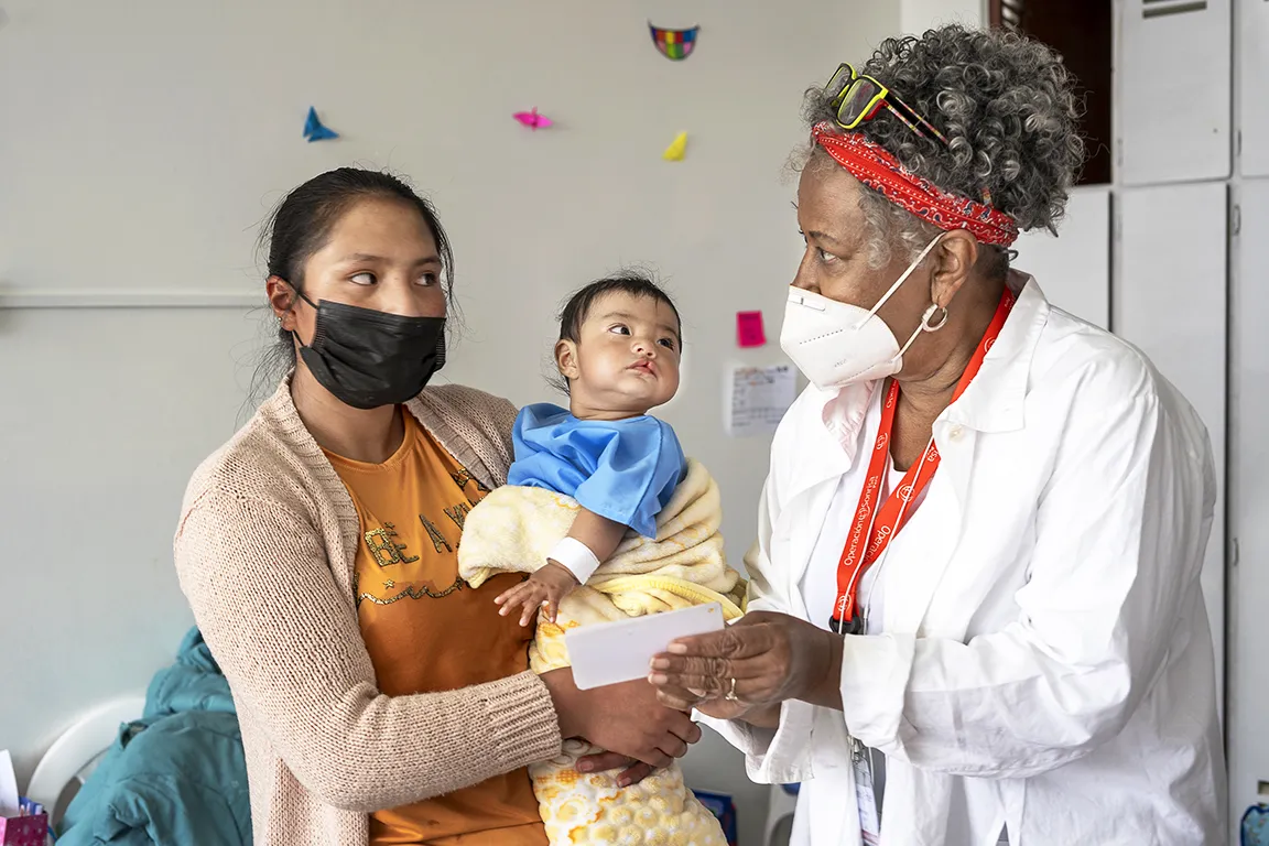 Longtime Operation Smile volunteer and student sponsor Barbara Higgins, right, speaks with a patients’ mother during a comprehensive health evaluation during Operation Smile’s June 2022 Women in Medicine surgical program in Lima, Peru.